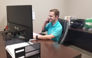 INTEGRA Staff Jared Priddy Talking on the Phone Sitting at a Desk