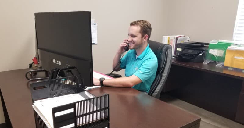 INTEGRA Staff Jared Priddy Talking on the Phone Sitting at a Desk